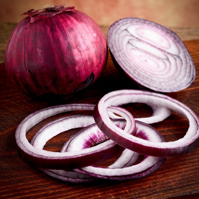 Red Burgundy onion whole and sliced rings on wooden surface