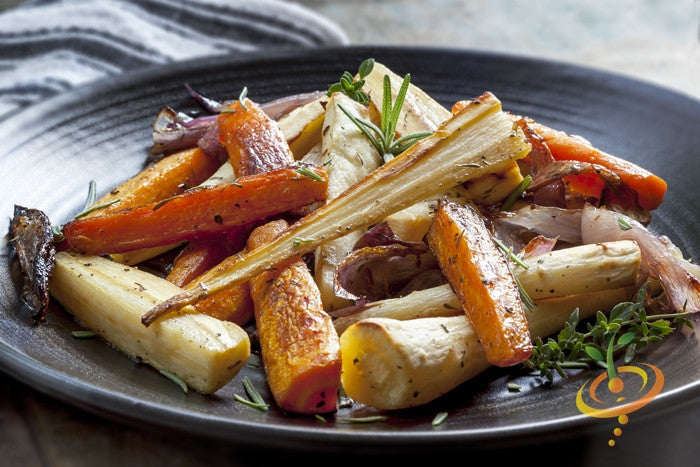 Roasted Harris Model parsnips and carrots garnished with herbs on a dark plate